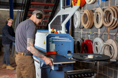 A photo of a team member/woodworker making bespoke display units for a shop